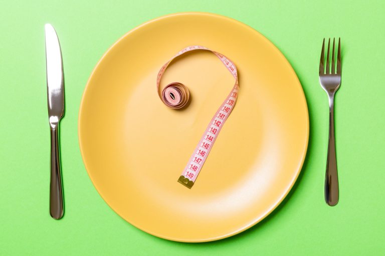 Question mark made of measuring tape on round plate