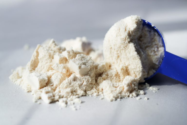 Scoop of natural taste whey protein powder. Close up.